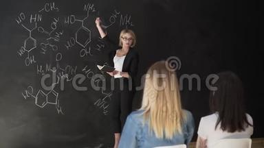 教师在粉笔板上书写公式，并向学生<strong>讲解</strong>公式..